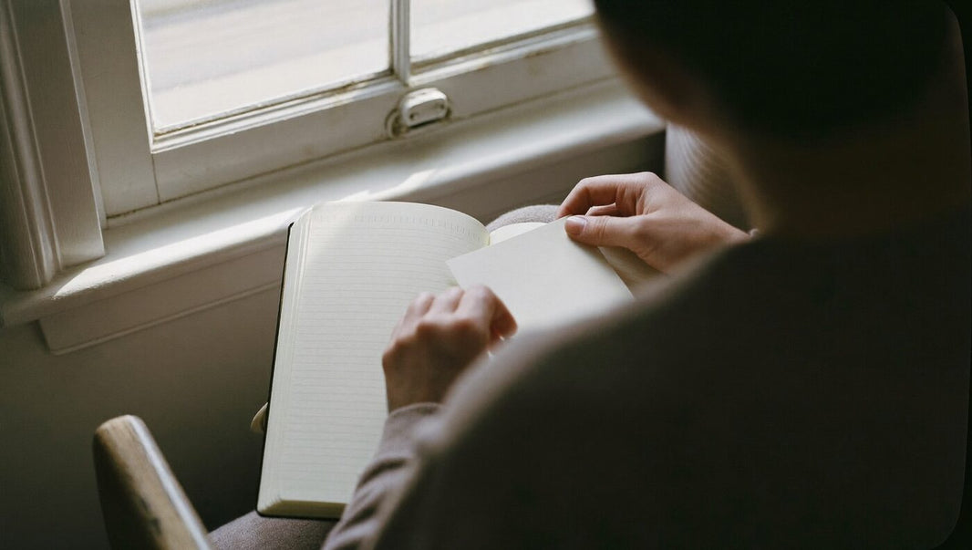 Person am Fenster mit Wertekarte und Notizbuch: prüfen, wie sich die eigenen Werte verändern