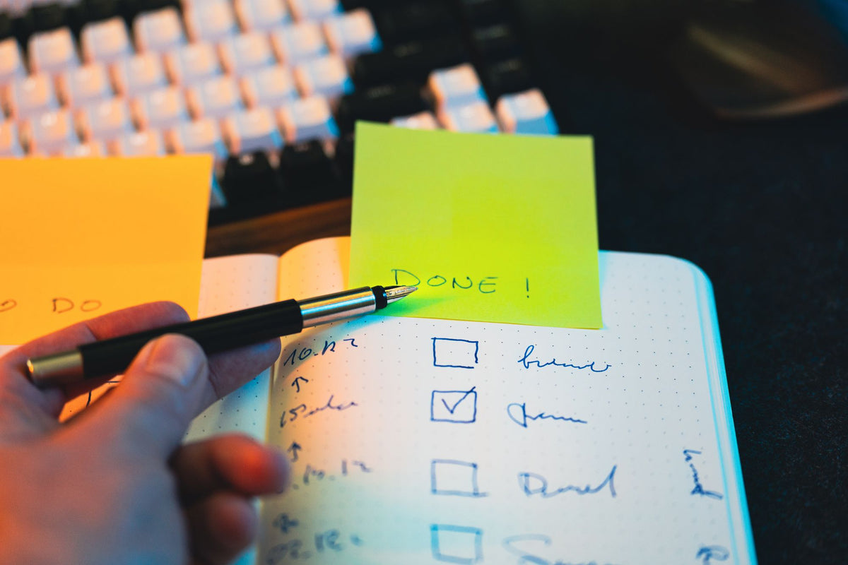 Stift über einer Checkliste mit Haftnotizen