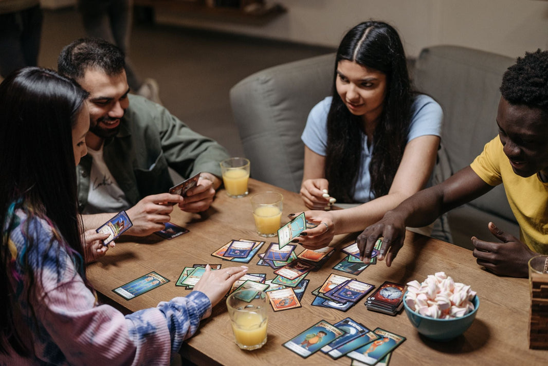 Freunde spielen Karten am Tisch mit Getränken