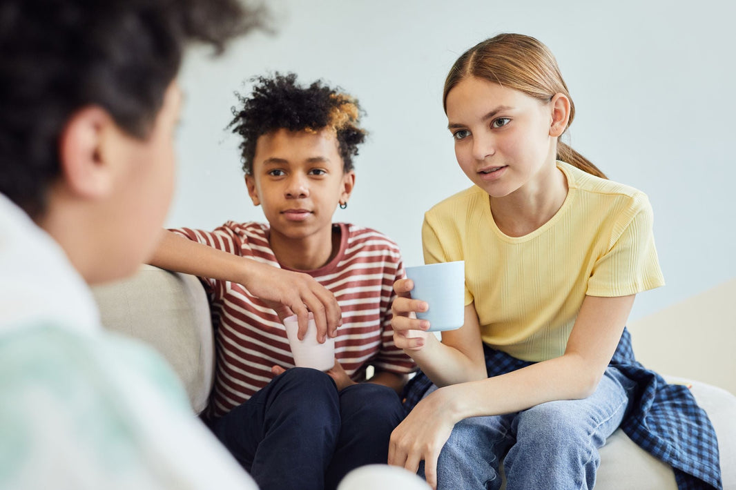 Jugendliche sitzen auf dem Sofa und unterhalten sich