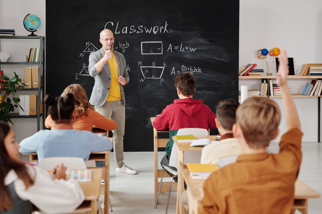 Lehrer erklärt, Schülerinnen und Schüler melden sich im Klassenzimmer