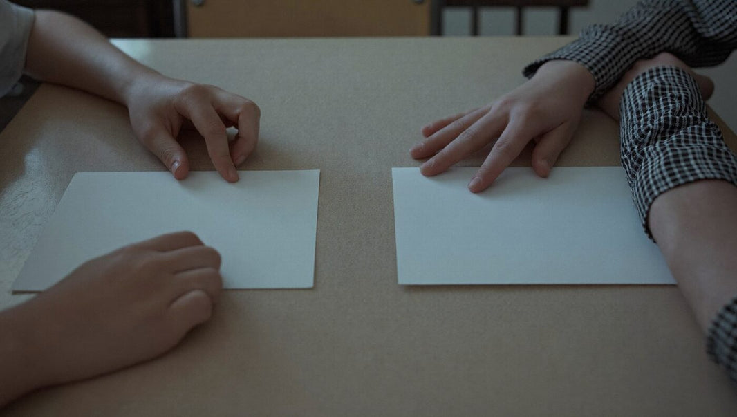 Zwei Hände legen zwei Wertekarten nebeneinander auf den Tisch, Wertekarten zum Ausdrucken und Spielen